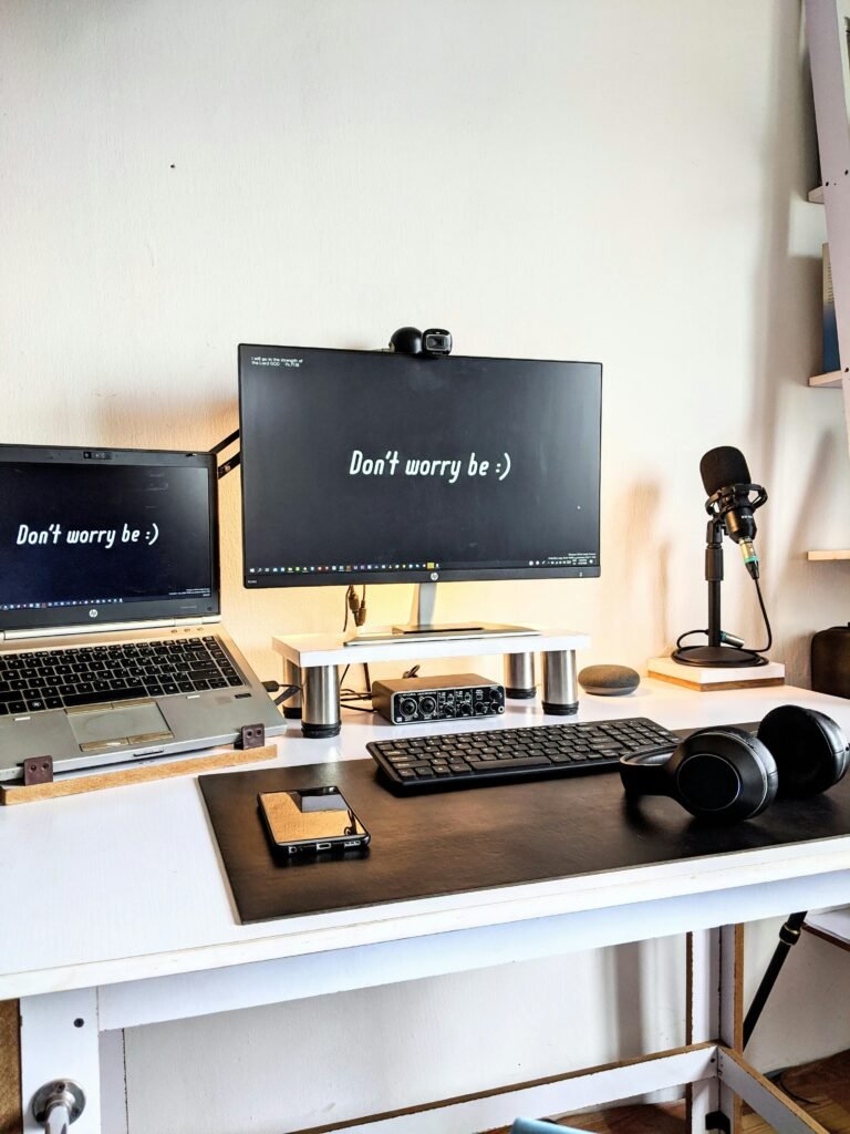 Laptop raised to eye level on a stand on a small desk, with a clean minimalist setup.
