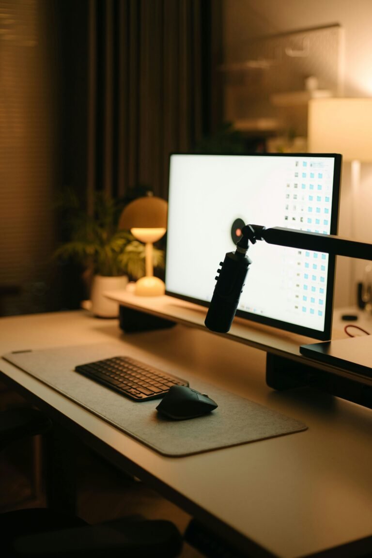 Small desk with a clamp-on lamp or monitor light bar - a clean minimalist workspace with good lighting and no bulky lamp.