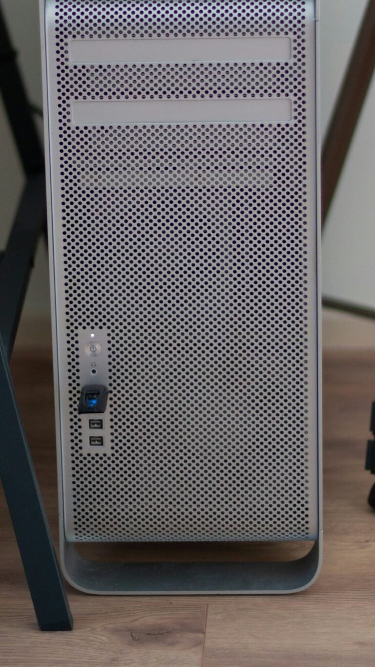 A desktop computer tower standing on the floor beside a desk leg